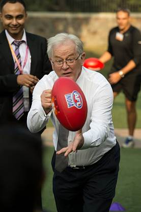 Minister Andre Robb hand-passing the AFL India Footy